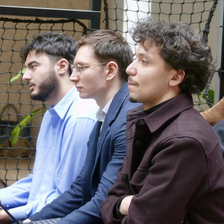 Trois étudiants écoutent un discours
