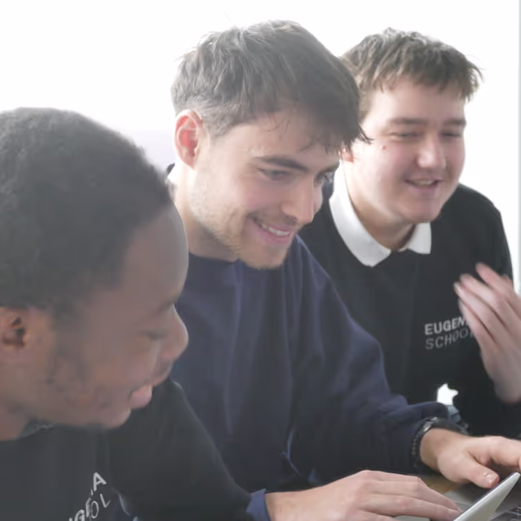 Trois étudiants s'entraident sur un travail
